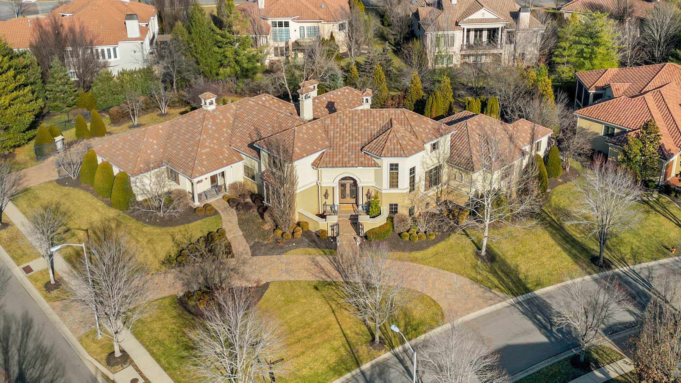 Aerial view of a Tuscan-style home with a large circle drive.