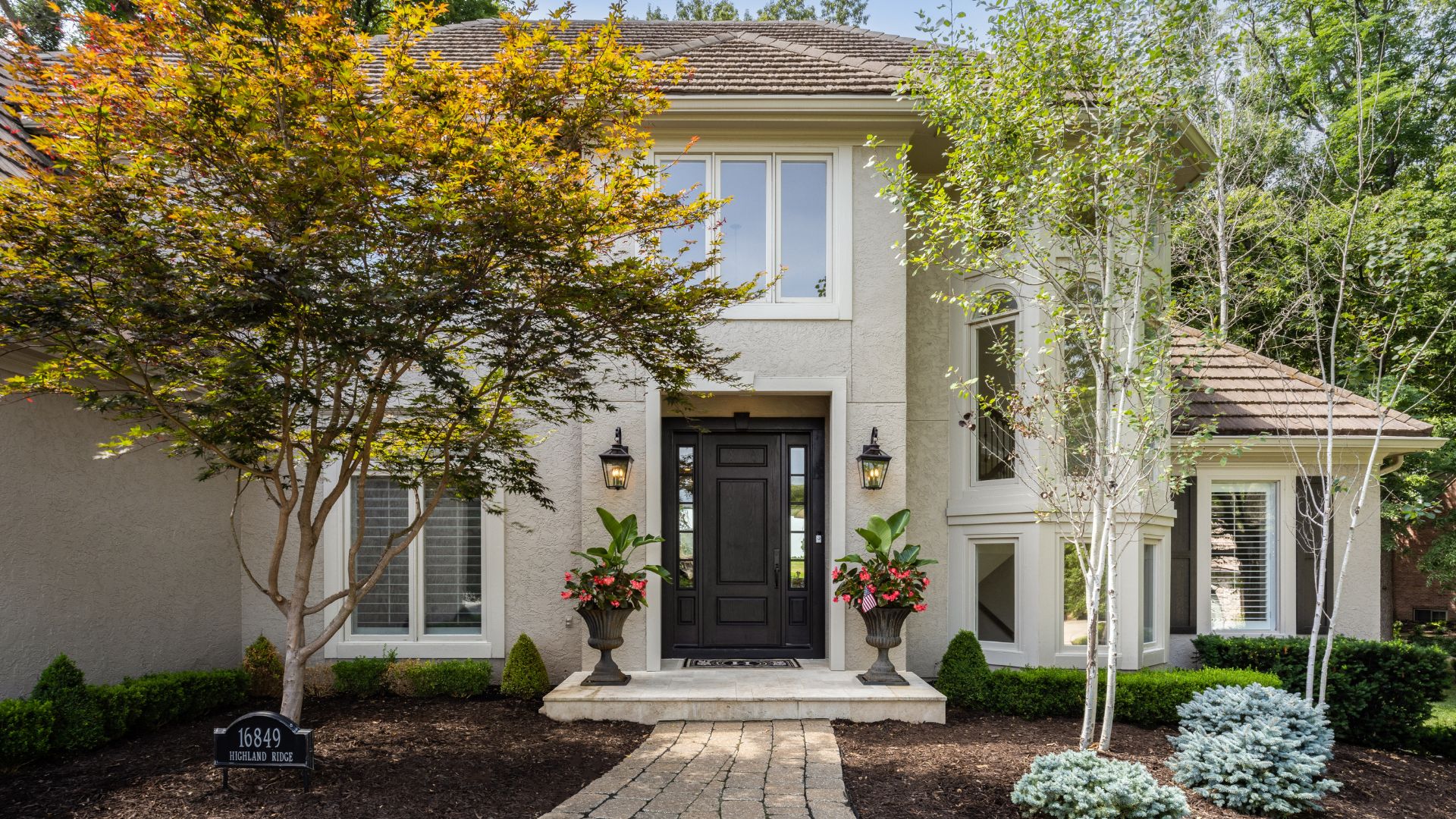 Up close shot of front of home with small porch and nice landscaping