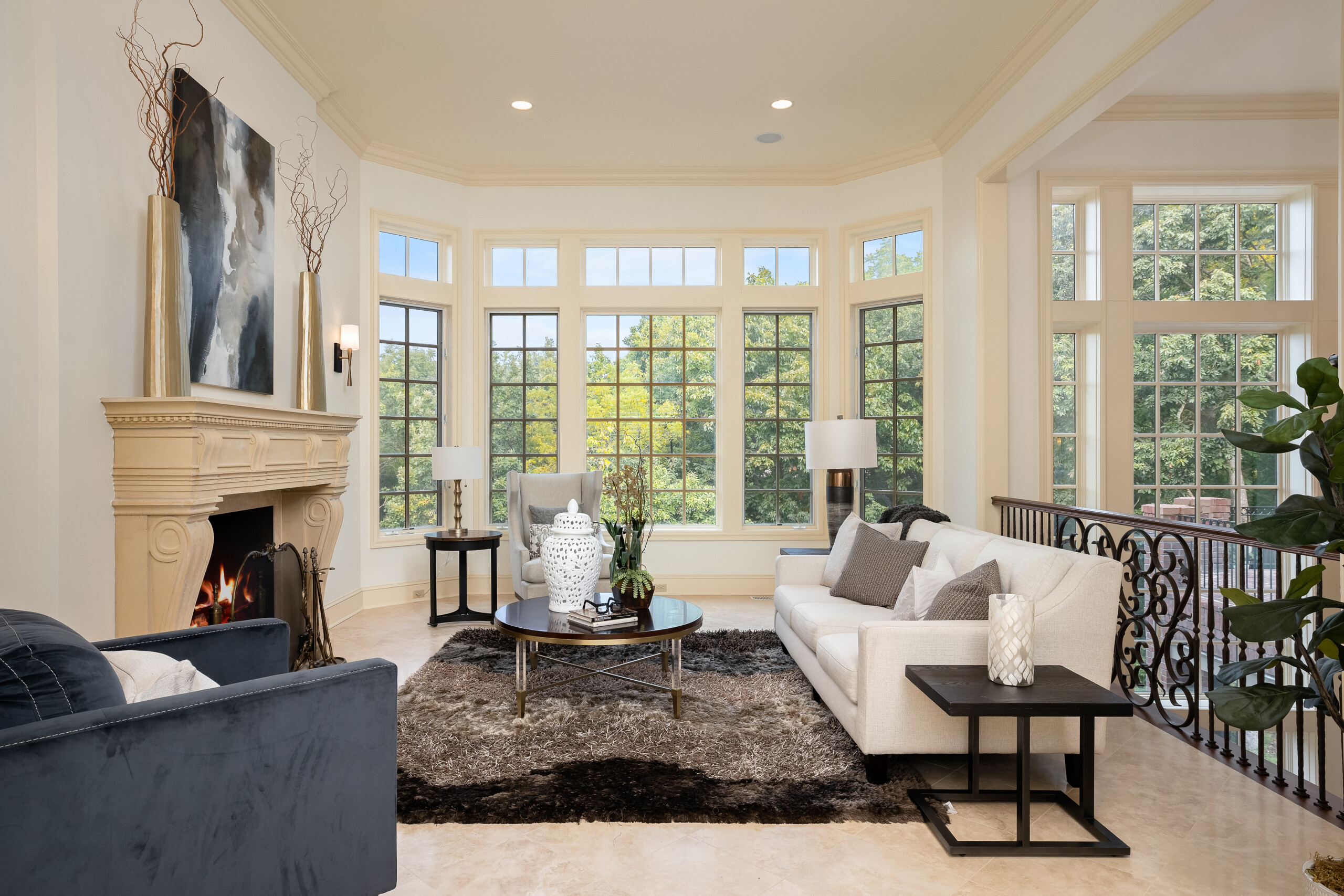 Living room staged with modern furniture and a lot of natural light from windows.