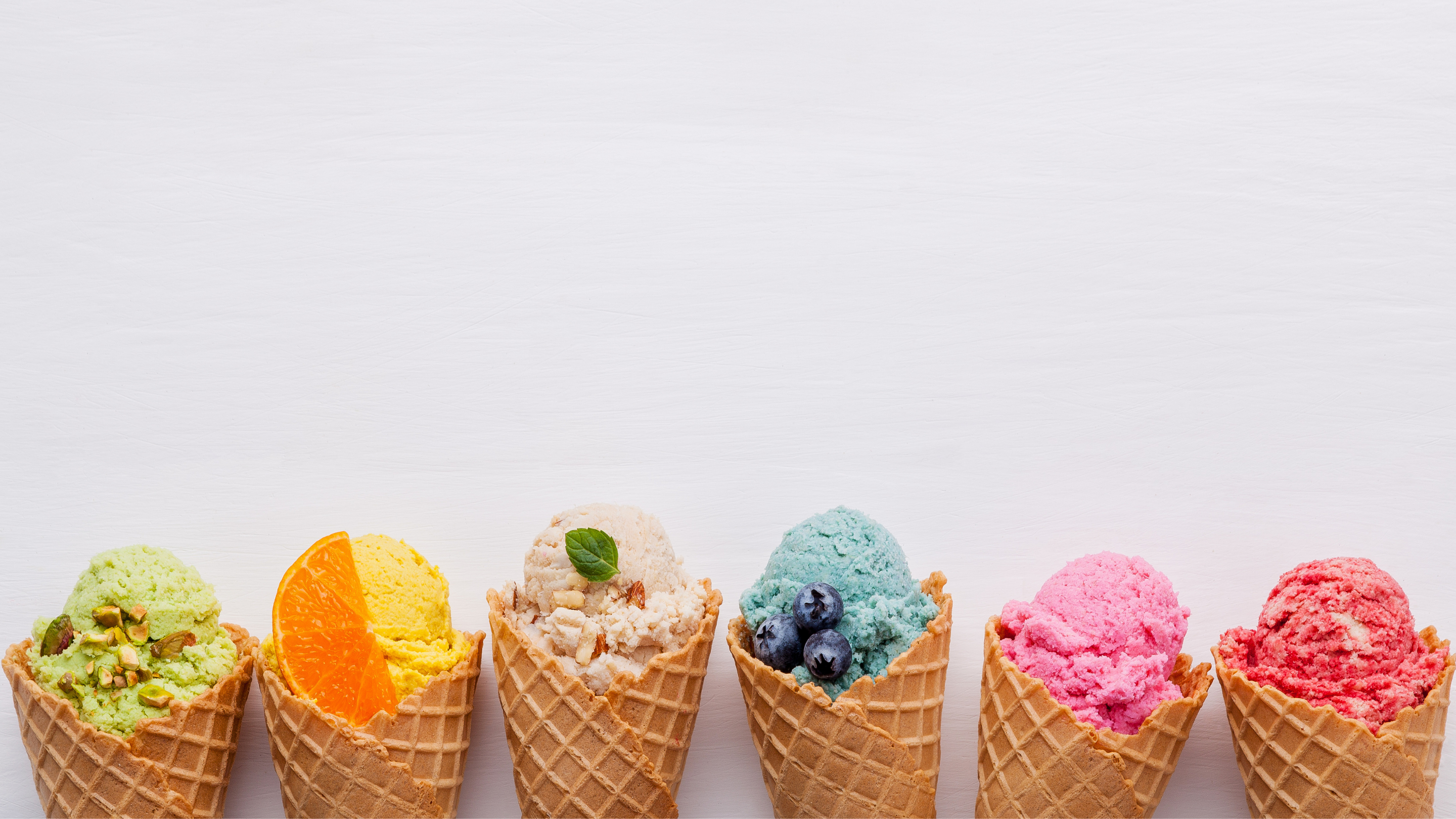 six colorful ice cream scoops in waffle cones