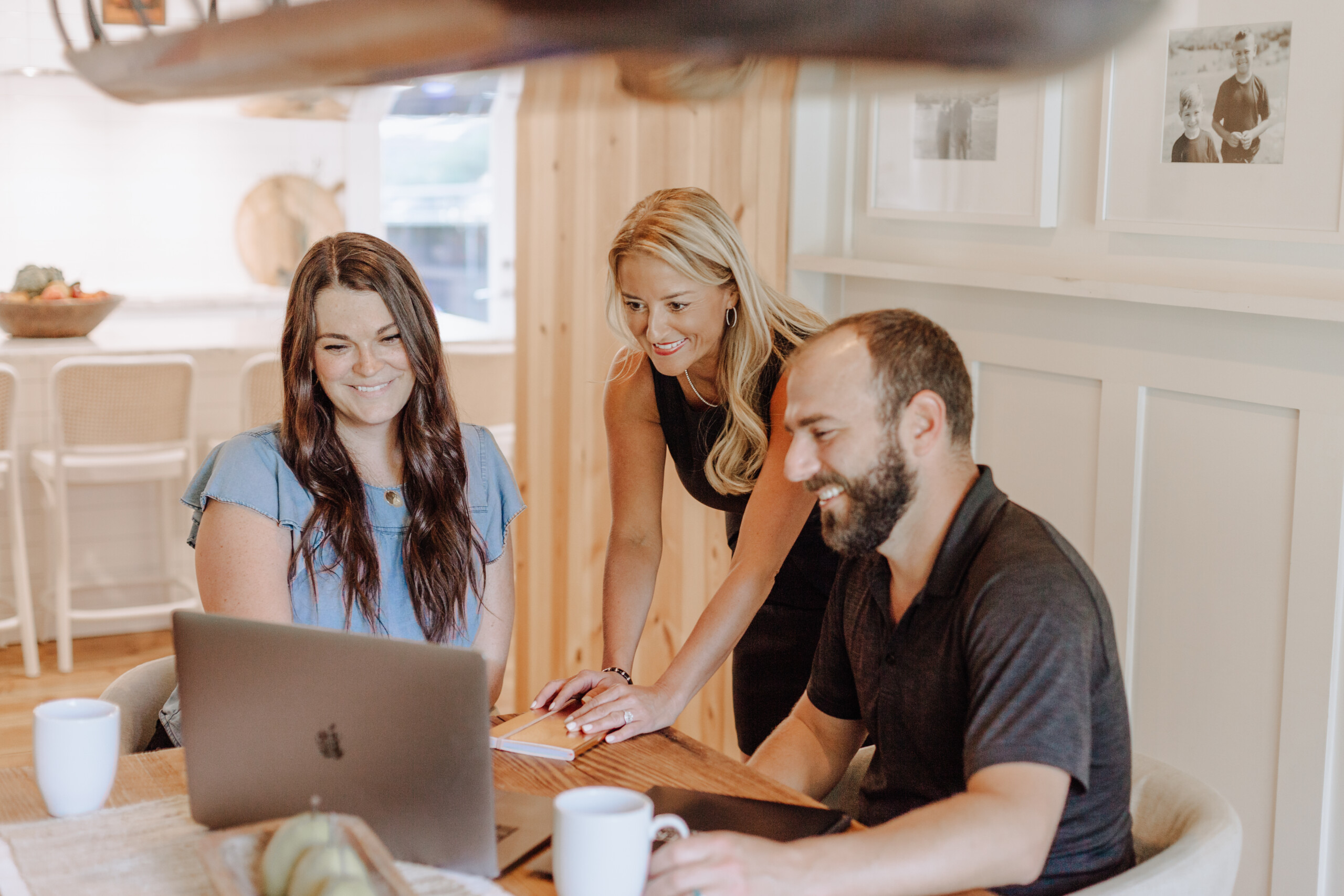 realtor pointing to laptop with clients