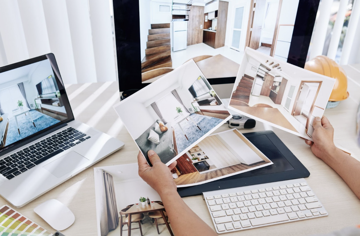 Person holding photos of the interior of a home